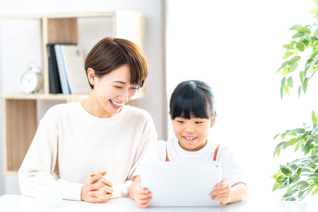 タブレットを見る女の子と母親